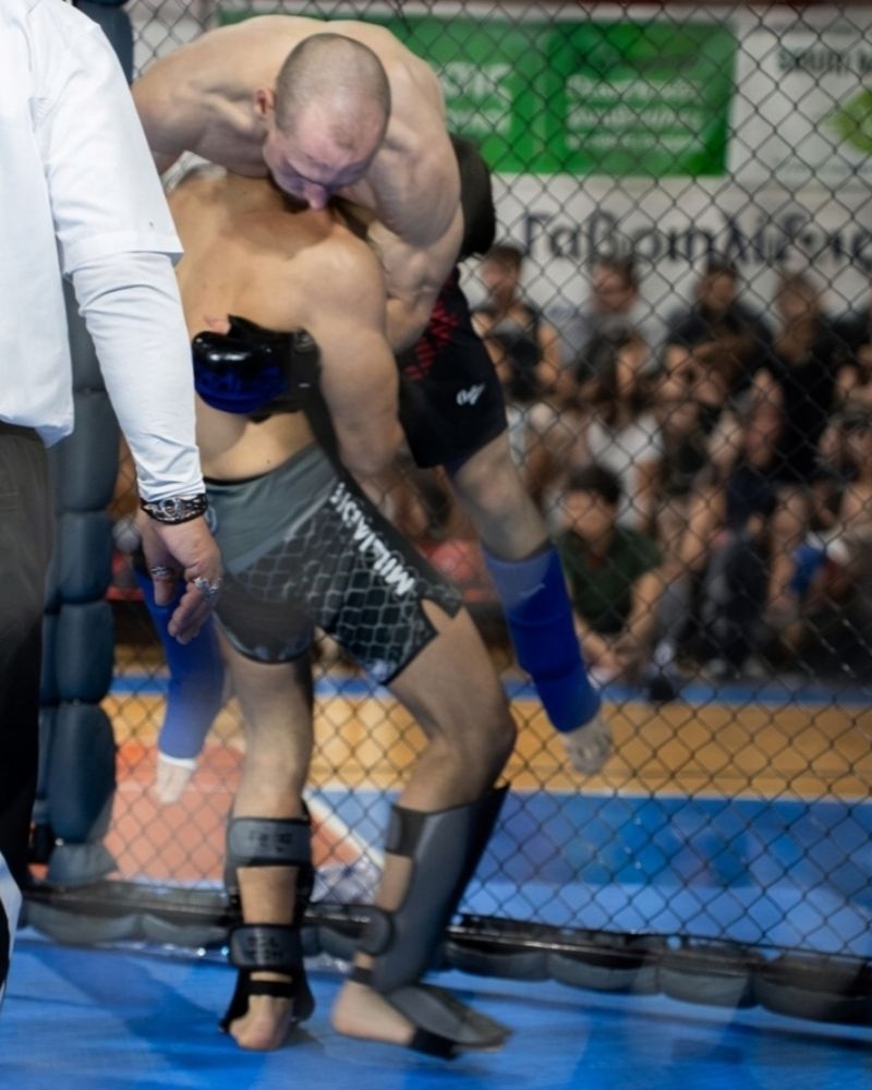 Miliadis Nikos (Μηλιάδης Νίκος), Greek MMA fighter, in a clinch with an opponent with the referee in front