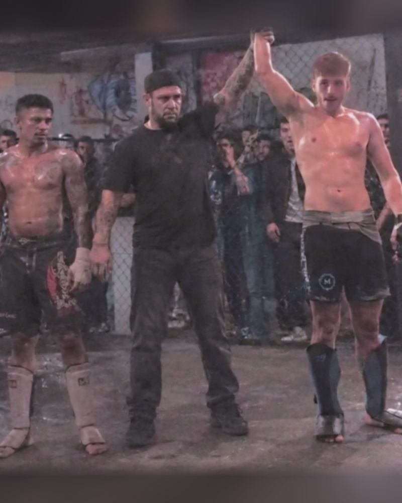 Miliadis Nikos (Μηλιάδης Νίκος), Greek MMA fighter, with his hand raised beside the referee and his opponent